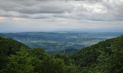 A dramatic landscape unfolds from the cliffs of Nyír-kő, looking north toward Mályinka, with...