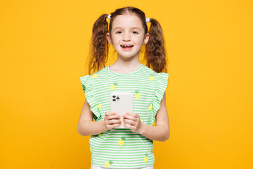 Little smiling cheery fun cute kid child girl 8-9 years old wears green t-shirt holding in hand use...