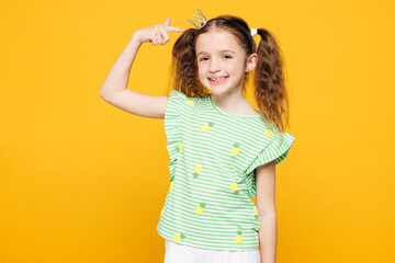 Little smiling cheery fun cute kid child girl 8-9 years old she wears green t-shirt point index...