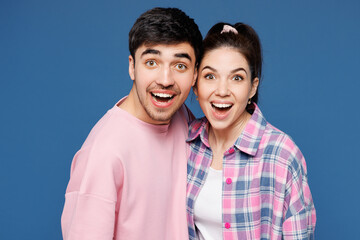 Fototapeta premium Close up young shocked surprised amazed couple two friends family man woman they wearing pink casual clothes together look camera isolated on plain blue background studio portrait. Lifestyle concept.