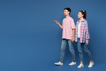 Full body sideways young couple two friends family man woman they wear pink casual clothes together...
