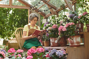 Joyful moments in a blooming garden with a senior woman enjoying her favorite book