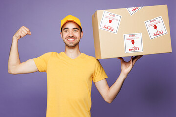 Delivery strong guy employee man wears yellow cap t-shirt uniform workwear work as dealer courier...
