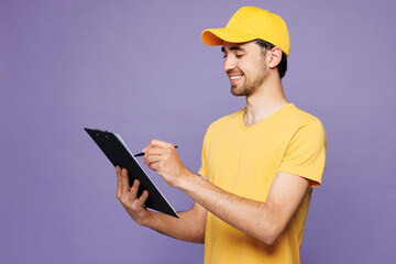 Sideways young delivery guy employee man wear yellow cap t-shirt uniform workwear work as dealer...