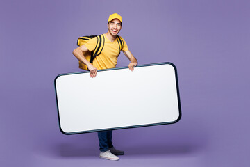Full body young delivery guy employee man in yellow cap t-shirt uniform workwear thermal bag work...