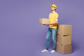 Full body young delivery guy employee man wear yellow cap t-shirt uniform workwear work as dealer...
