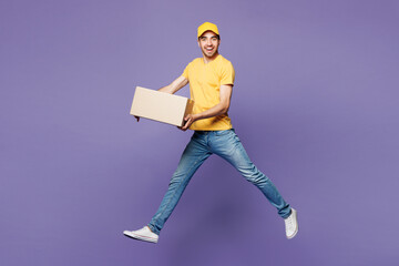 Full body young delivery guy employee man he wear yellow cap t-shirt uniform workwear work as...