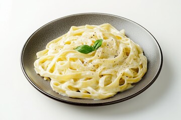 Delicious creamy fettuccine pasta served on an elegant plate with fresh basil garnish
