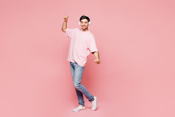 Full body young fun Caucasian man he wear t-shirt casual clothes listen to music in headphones...