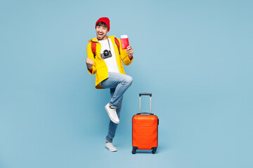 Traveler man wears yellow casual clothes hold bag passport ticket do winner gesture isolated on...