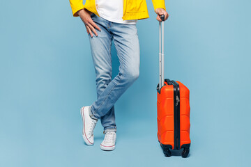 Close up cropped traveler man wearing yellow casual clothes hold suitcase bag isolated on plain...