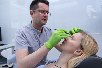 Expert Cosmetic Practitioner Performing Facial Enhancement Procedure with Precision as Patient...
