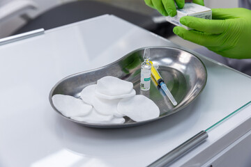 Prepared Medical Tray with Cotton Pads, Syringe, and Vial in a Clinical Setting for Injection Procedures