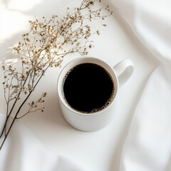 Minimalist coffee mug with dried flowers on white fabric background