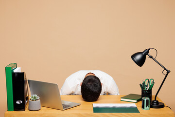 Young tired exhausted sad hardworking employee business man wear white shirt tie sit work put head...