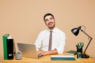 Young successful employee IT business man wear white shirt tie sit work at office desk use laptop...