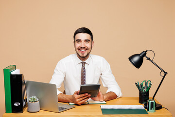 Young smiling successful employee business man wear white shirt tie sit work at office desk with pc...