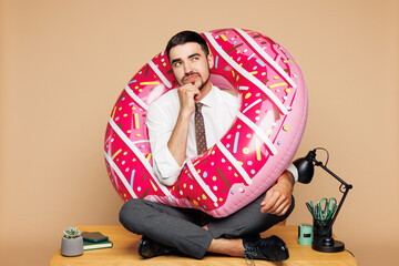 Full body young employee business man wear white shirt tie donut rubber ring sit work at office...