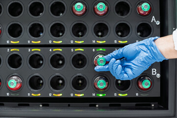 Close up researcher hand wear blue gloves placing bottles into blood culture instrument.Scientists...