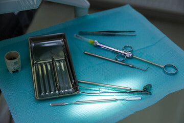 A Close-Up View of Surgical Instruments on a Blue Surgical Mat in a Clinical Environment, Ready for...