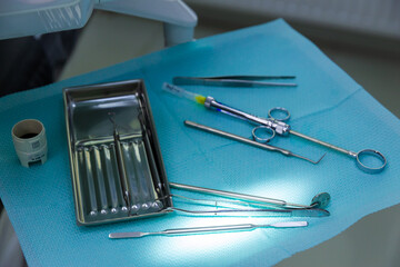 A Detailed Look at Surgical Instruments on a Blue Tray in a Clinical Setting, Highlighting Their...
