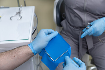 Dental Procedure in Progress: A Close-Up of a Dentist Preparing Equipment and Patient for Treatment...