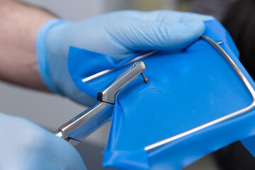 Healthcare Professional Handling Surgical Instrument with Blue Protective Covering During Clinical...