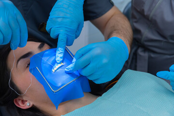 Dental Professionals Perform a Precise Procedure Utilizing Advanced Tools for Oral Care with Blue...
