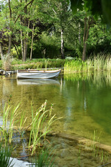 White  vintage style boat at the edge of the pond