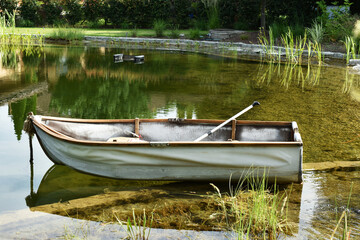 White  vintage style boat at the edge of the pond