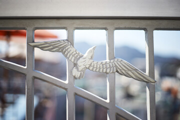 Decorative metal railing with embossed flying bird design and urban background