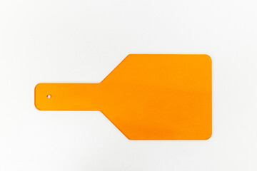 A Bright Orange Paddle Tool Against a White Background: Practical Uses in Various Applications Including Cooking, Art, and Educational Settings