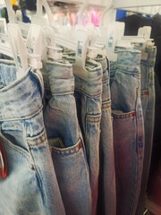 blue jeans hanging on a hanger in a store