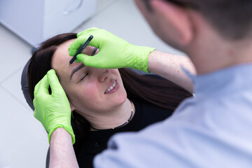 A Client Receiving Professional Eyebrow Shaping Through Precision Techniques from a Skilled...
