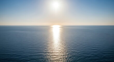 Obraz premium Sunlight reflects on the calm ocean surface at sunset
