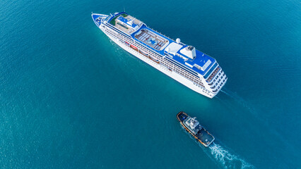 Aerial top view of a luxury cruise ship sailing through deep blue ocean water. Vibrant deck design...