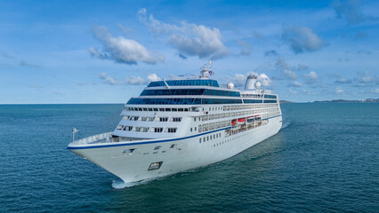 Aerial top view of a luxury cruise ship sailing through deep blue ocean water. Vibrant deck design...