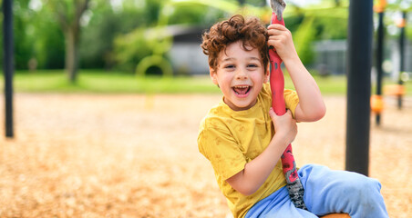 Happy 5 years old boy on a playground © Louis-Paul Photo