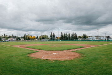 Baseball field home plate pitcher mound green grass outdoor cloudy sky autumn empty sports recreation