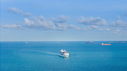 Aerial top view of a luxury cruise ship sailing through deep blue ocean water. Vibrant deck design...
