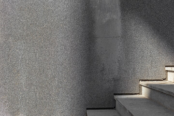 gray empty concrete wall with sunlight and shadows with stairs in summer day minimalistic...