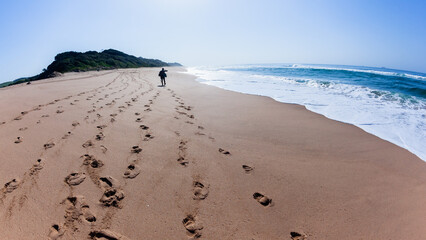 Beach Ocean Distant Man Walking Footprints Along Blue sky Morning Landscape.