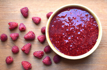 Delicious puree of ripe raspberries in a wooden bowl. Flat lay, top view
