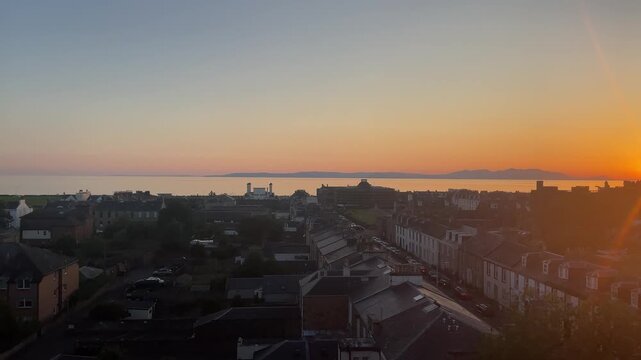 Breathtaking panoramic view of Ayr, a charming coastal town in Scotland, showcasing its historic buildings, waterfront, rolling hills, and picturesque landscape under clear skies

