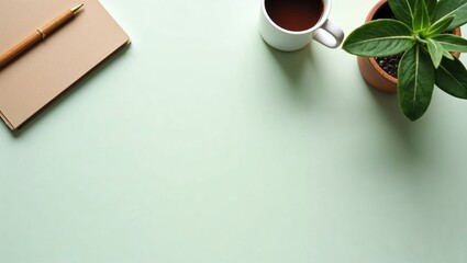 A minimalist workspace from a top-down view. On a light green table are a notebook, a pen, a cup of coffee, and a houseplant in a terracotta pot. The space is open for creativity.