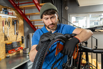 Master fixes bike wheel in organized garage with modern setup