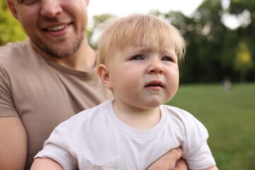 Fototapeta premium Smiling dad and his newborn baby outdoors, closeup. Happy Father's Day