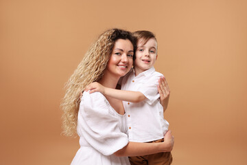 Family. Happy mother and her son on beige background