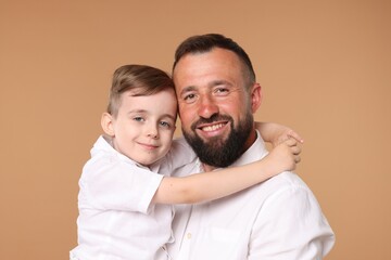 Family portrait of happy father and his son on beige background