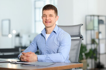 Portrait of handsome man at desk in office